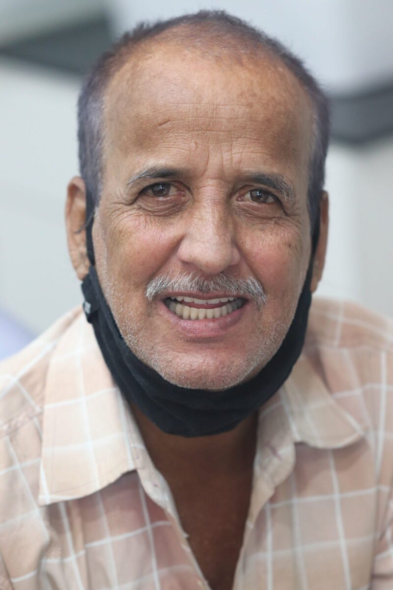 A patient wearing dentures made by Dr. Gaurav Goel, best dentist in noida for dental implants and dentures at Dentessence, Best dental clinic in noida